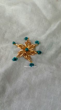 a gold brooch with blue beads on it