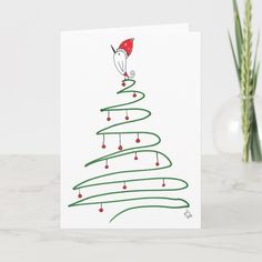 a card with a christmas tree on it and a santa hat hanging from the top