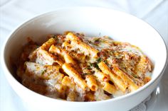 a white bowl filled with pasta and sauce