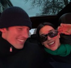 a man and woman sitting in the back seat of a car with their arms around each other