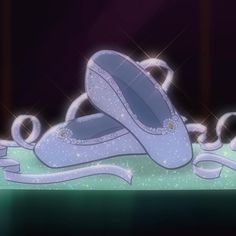 two blue ballet shoes sitting on top of a green floor next to a purple wall