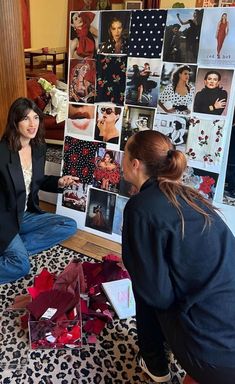 two women sitting on the floor in front of pictures