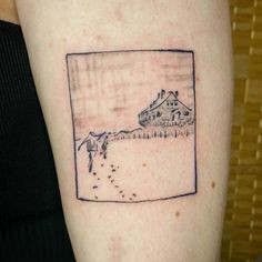 a drawing on the back of a woman's arm shows a house and water