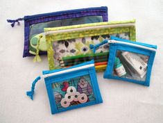 three small zippered pouches with pictures on the front and one in the back