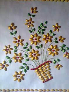 a vase filled with lots of flowers on top of a white table covered in gold and green beads