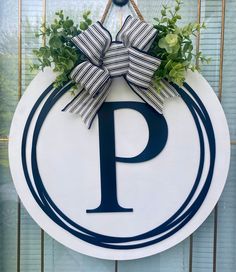 a blue and white sign with a bow hanging from it's side on a wall