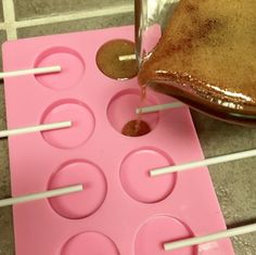 a cake being made with chocolate icing and marshmallows on a pink tray