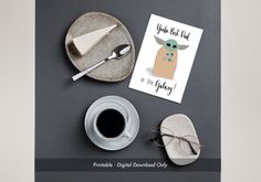 there is a card with an image of a baby yoda on it next to a cup of coffee