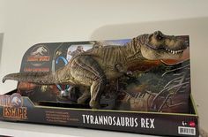 a toy tyrannosaurus is sitting on top of a box