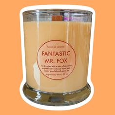 a candle that is sitting on top of a glass container with the words fantastic mr fox in it