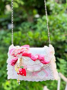 Step into a world of whimsy with this charming crossbody bag, designed with a classic flap closure that exudes elegance and style. The flap is adorned with an enchanting bow ribbon, embellished with a delightful strawberry charm and beaded tassels that add a playful touch. Both the flap and the sides of the bag feature delicate ruffle trim, enhancing its feminine allure.The bag showcases a unique crisscross design that adds a hint of sophistication, making it a perfect accessory for any lolita o Light Pink Bow, Steampunk Fashion Male, Strawberry Charm, Steampunk Accessories, Bow Ribbon, Blossom Design, Pretty Bags, Sweet Lolita, Steampunk Fashion