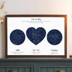 three framed stars in the shape of hearts on a shelf next to a potted plant