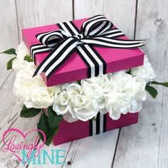 a pink box with white flowers in it