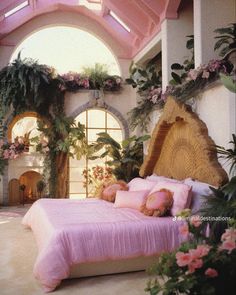 a bedroom with pink bedding and flowers on the ceiling, along with arched windows