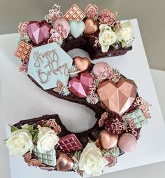 a birthday cake decorated with flowers and chocolates