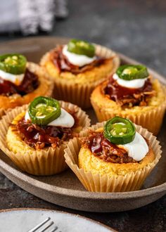 mini taco cups on a plate topped with sour cream and jalapenos