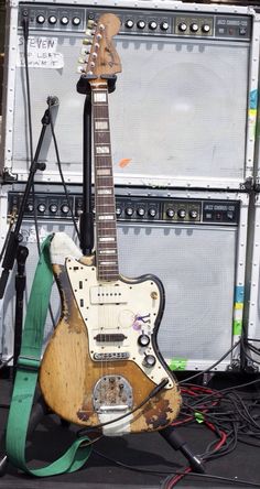 an electric guitar sitting on top of a table next to a microphone and amps