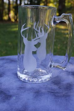 a glass mug with a deer on it