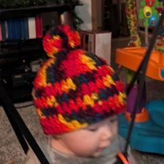 a small child wearing a multicolored knitted hat