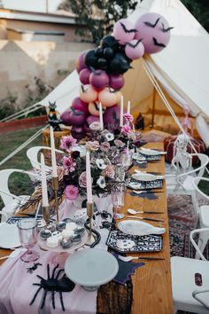 a table set up with halloween decorations and balloons