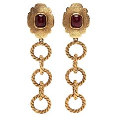 The luxurious creation of Maison Gripoix exclusively for Chanel, are clip-on 1980s vintage Chanel earrings boast a large central ruby red stone in Gripoix glass set on a gold-toned base with oversized chainlink embellishment. Pair these statement pre-owned earrings with your favourite gold-toned jewellery and red lipstick for added drama. Colour: Red/Gold Composition: Gold Plated Metal, Glass Measurements: Height 10.5 cm Weight (single earring) 23.79 g Width 2.5 cm Condition: Excellent condition Vintage Chanel Earrings, Gold Chanel, Chanel Earrings, Chanel Vintage, Old Money Aesthetic, Color Rojo, Red Stone, Accessories Jewelry Earrings, Single Earring