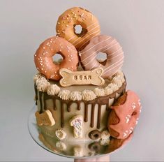 there is a cake with donuts and other treats on the top it's frosting