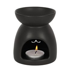 a black candle holder with a lit candle in it