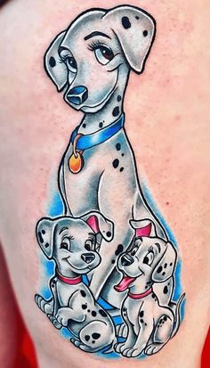 a woman's back with tattoos on her stomach and two dogs sitting next to each other