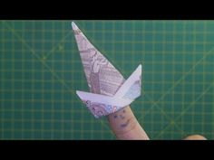 a person is holding up a small origami bird