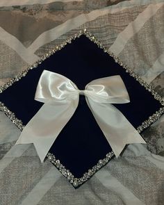 a blue and white graduation cap with a bow