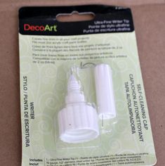 a white light bulb in a package on top of a cardboard box with an ad for decoart