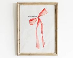 a red bow hangs on the wall above a framed print that says, be you mom