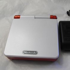 a nintendo wii game system sitting on top of a white table next to a charger