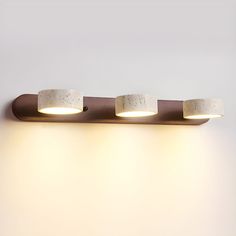 three lights that are on the side of a wall