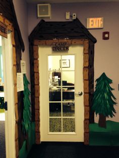 the front door to an office decorated with fake trees