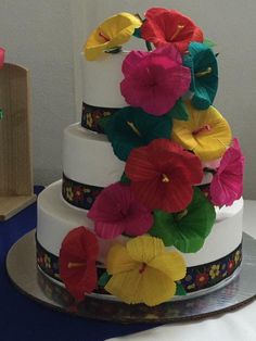 a multi - tiered cake decorated with colorful flowers