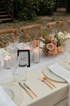 the table is set with candles, plates and napkins for an elegant wedding reception