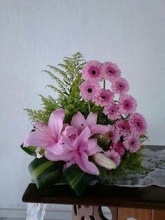 a bouquet of pink flowers sitting on top of a wooden table