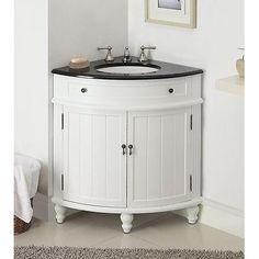 a white sink with black counter top in a bathroom next to a rug on the floor