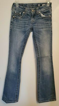 MISS ME JE1048BR Women's Jeans. Good previously owned condition. Boot Cut. Med Wash.  Back Flap Pockets with Embroidery and Bling. Thick Stitching. Distressed.  Women's Size 25. Measurements when flat: Waist 12.5 inches Hips 16 inches Rise 7 inches Inseam 30 inches Leg opening 7.75 inches Thank you for considering these Miss Me jeans! Thick Stitching, Tooth Gems, Love Jeans, Rock Revival Jeans, Bootcut Pants, Cute Fit, Girls Life, Miss Me Jeans, Workout Accessories