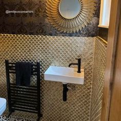 a bathroom with a toilet, sink and mirror on the wall next to a towel rack