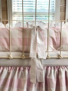 a crib with pink and white checkered sheets