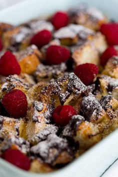 a casserole dish with raspberries and powdered sugar