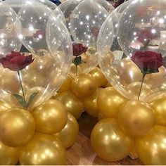 several balloons with roses in them on a table