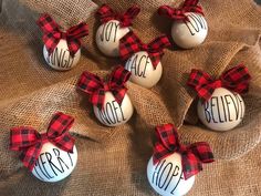 six christmas ornaments with red and black plaid bows on burlock wrapped in burlocks