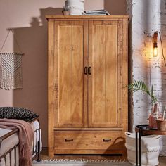 a bedroom with a bed and a wooden cabinet next to a brick wall in the corner