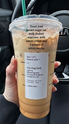 a person holding up a drink in their hand with a label on it that says, vanilla sugar cat milkshake