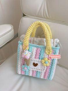 a crocheted bag sitting on top of a white chair next to a stuffed animal