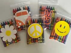 four bags of crayons with smiley face, peace sign and flower on them