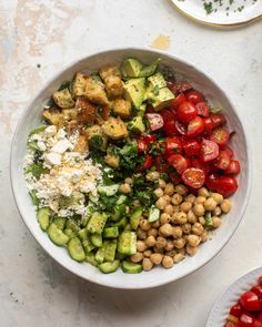 a white bowl filled with lots of different types of food on top of a table